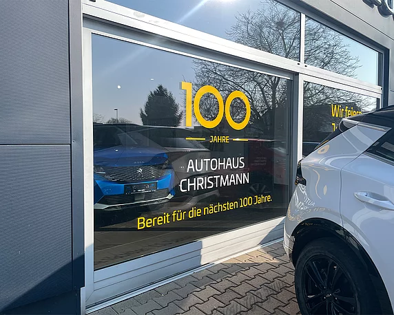 Seitliche Schaufensterbeklebung im Jubiläumsdesign für das Autohaus Christmann